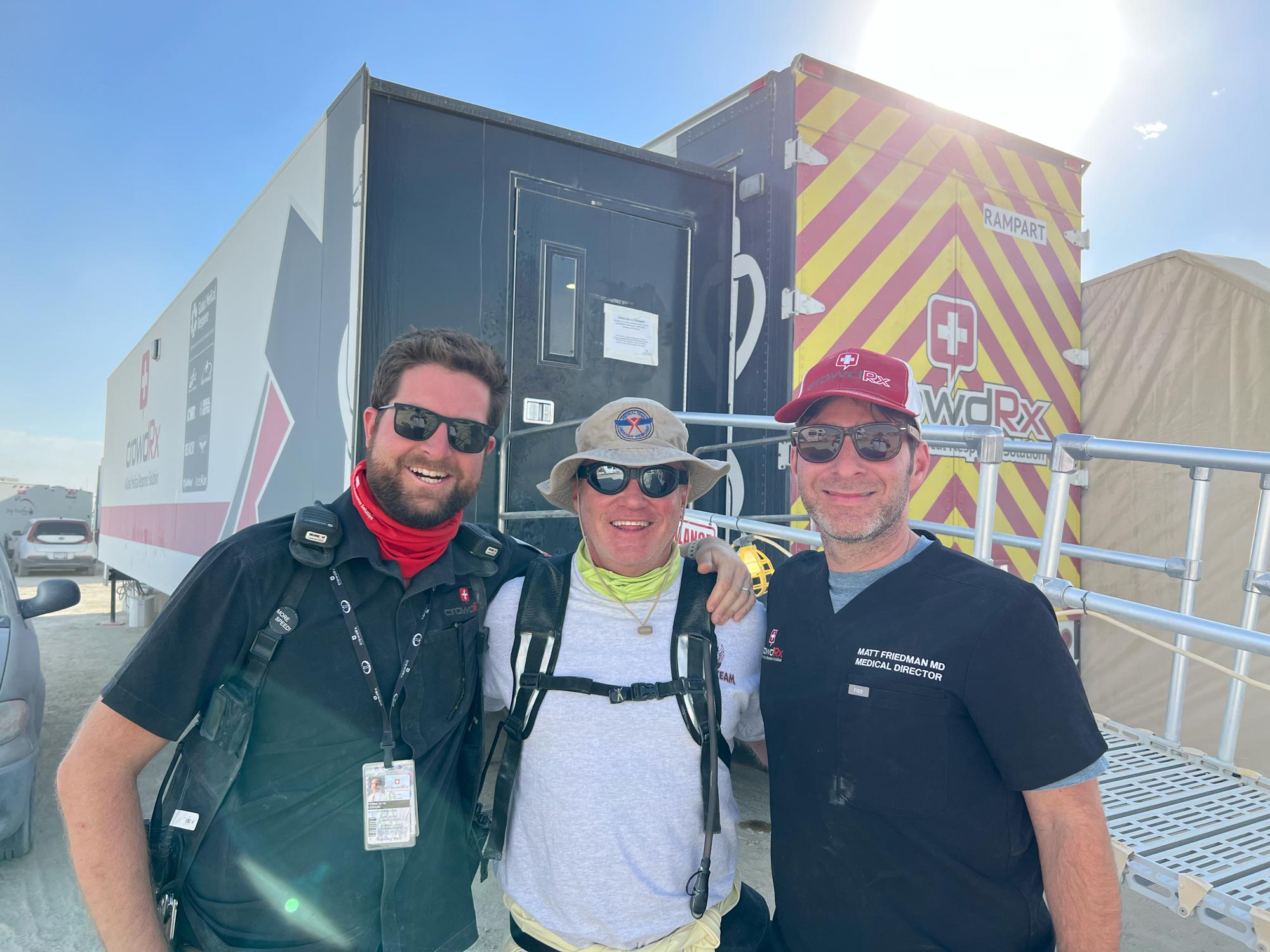 3 staff members posing in front of medical trailer